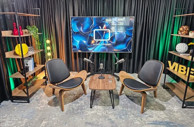 Cenário de entrevista com duas poltronas, mesa de centro e microfones